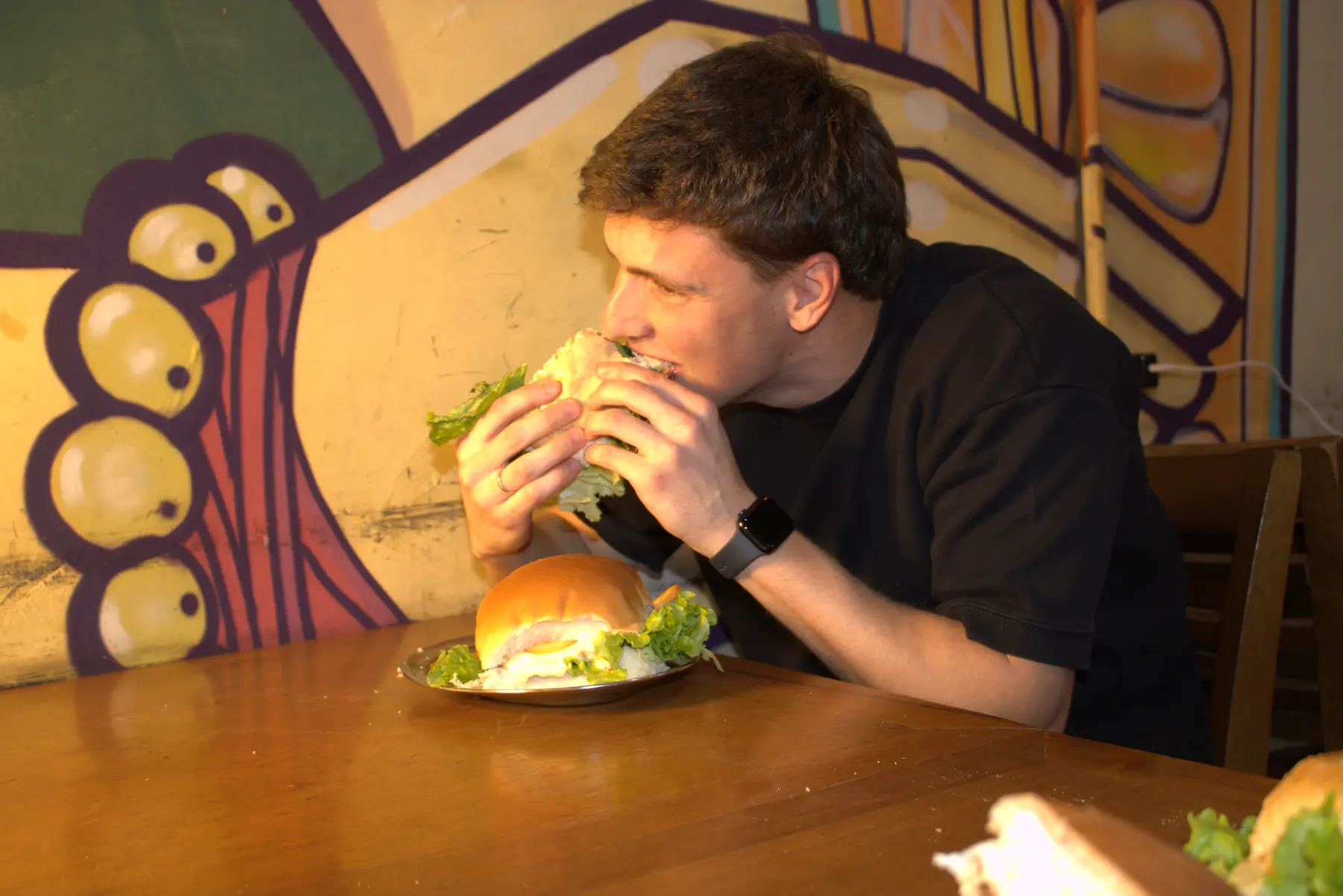 Cliente comendo um lanche da Nova Jaú