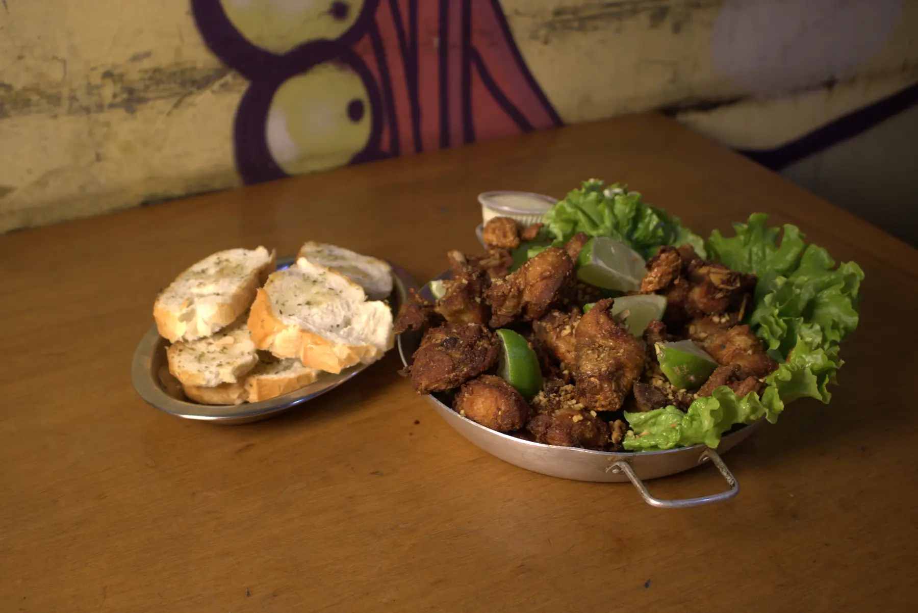 Porção de frango com pão, limão e folhas
